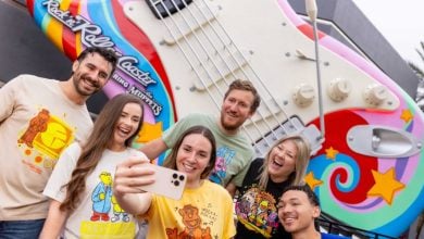 a group takes a selfie in front of rock n roller coaster starring the muppets guitar in disney's hollywood studios