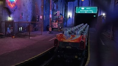 A vacant ride car waits on the neon-lit track inside the immersive tunnel of the theme park’s signature attraction.