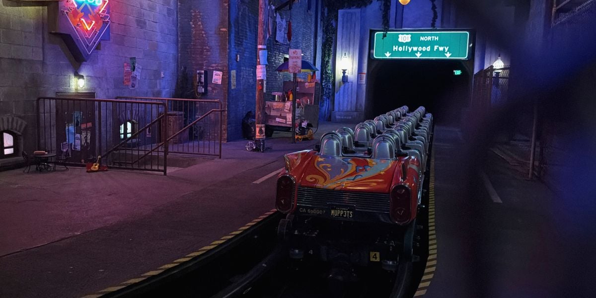 A vacant ride car waits on the neon-lit track inside the immersive tunnel of the theme park’s signature attraction.