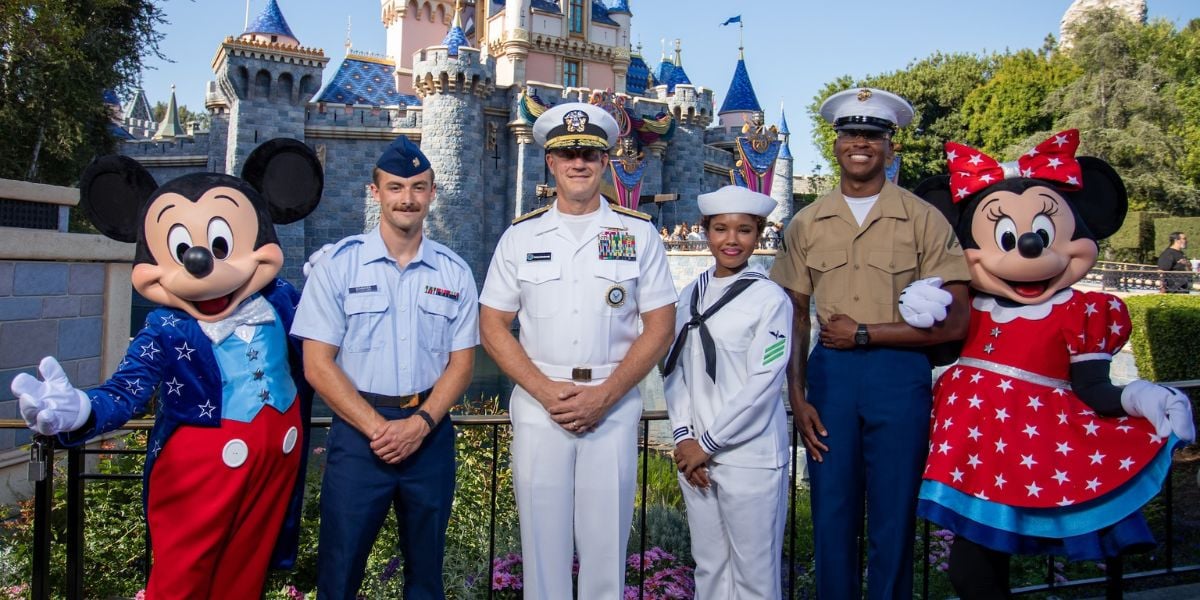 Mickey and Minnie Mouse join five U.S. military members for a photo in front of Disneyland’s Sleeping Beauty Castle.
