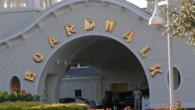 Iconic BOARDWALK entrance arch gleams with gold letters as guests and cars arrive for adventure and fun on the lively promenade.