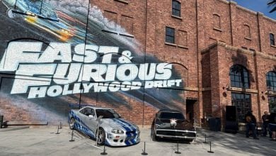 Fast & Furious movie cars displayed in front of the "Fast & Furious Hollywood Drift" mural at Universal Studios.