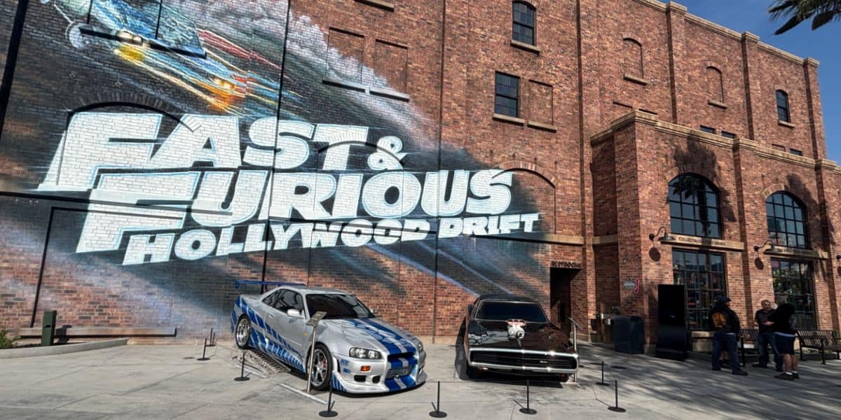 Fast & Furious movie cars displayed in front of the "Fast & Furious Hollywood Drift" mural at Universal Studios.