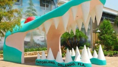 Iconic Gatorland entrance featuring a giant alligator mouth sculpture, welcoming guests amid lush Orlando greenery.