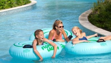 Guests enjoy laughter and fun as they float on inner tubes down the lazy river at an Orlando resort’s water park under the sun.
