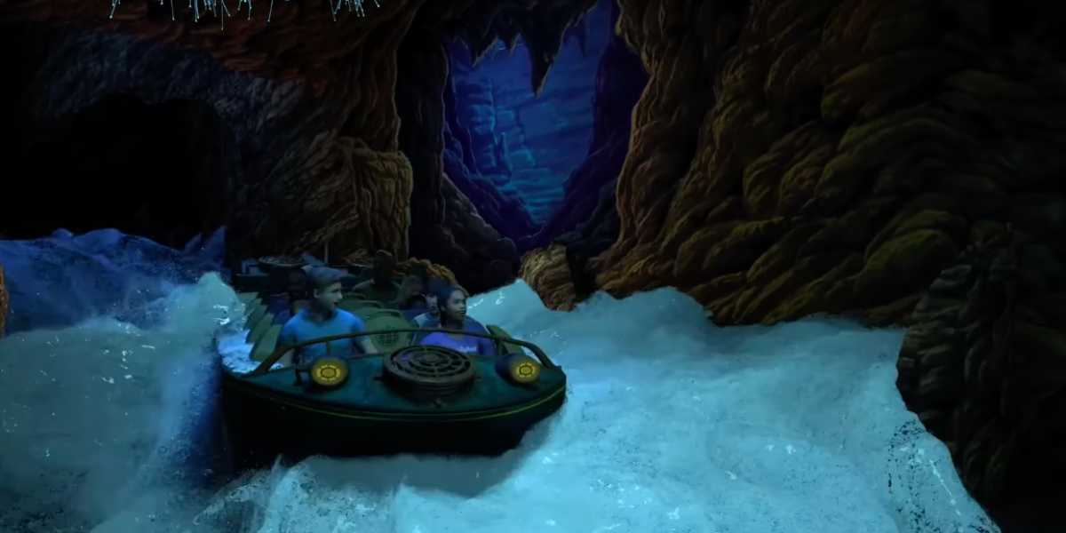 Guests sail through a thrilling cave adventure, navigating rushing waters and rugged rock walls on an exciting theme park ride.