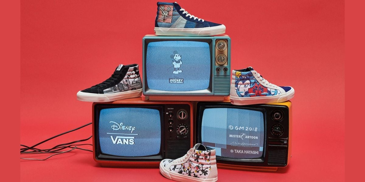 Disney x Vans sneakers showcased atop vintage TVs with classic Disney cartoons, set against a vibrant red backdrop, ready for fans.