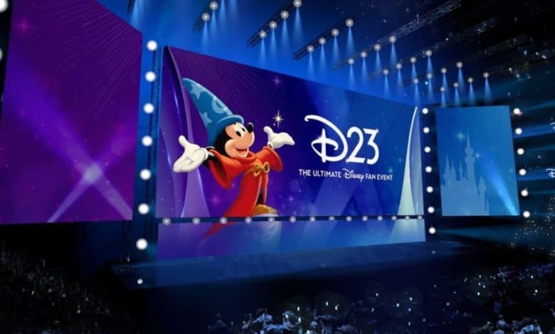Sorcerer Mickey takes center stage with the iconic D23 logo, entertaining an excited crowd of Disney fans inside the lively arena at the Anaheim Show Floor.
