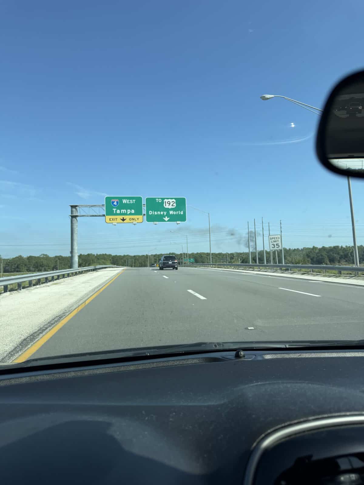 View from a car cruising down the highway toward signs for Tampa, Exit 6, and Disney World Resort, with blue skies overhead—an everyday drive that could turn into an adventure worthy of the big screen if a 911 call reported a fire emergency.