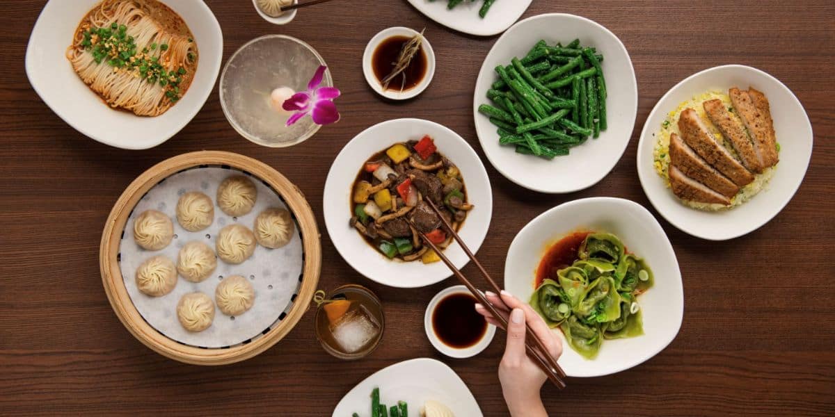 Chinese dishes like dumplings, noodles, and green beans on a table—an appetizing feast near Disneyland’s Downtown Disney.