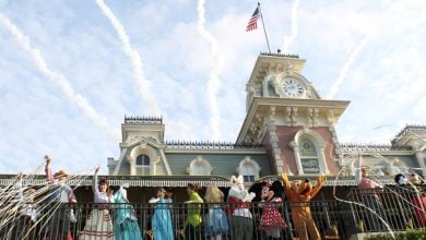 Mickey Mouse and friends wave to fans from the balcony of the Main Street USA train station at Magic Kingdom