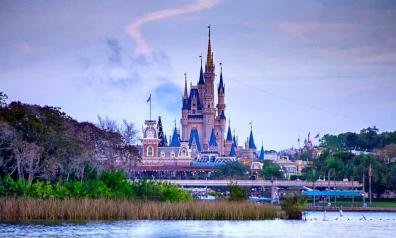 Guests walk through Magic Kingdom with Cinderella Castle visible at Walt Disney World Resort in Florida.