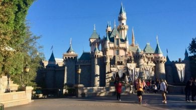 Guests stroll toward Sleeping Beauty Castle at Disneyland Park
