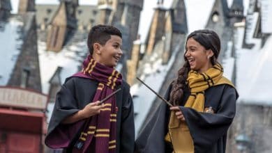 guests in wizard robes with wands in Hogsmeade at Universal Orlando's Wizarding World of Harry Potter