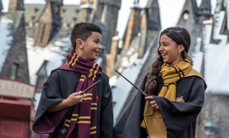 guests in wizard robes with wands in Hogsmeade at Universal Orlando's Wizarding World of Harry Potter