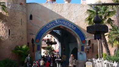 Guests walk beneath the iconic Adventureland archway at Disneyland Paris