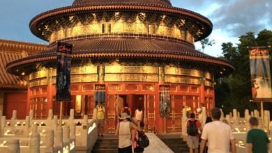 Guests stroll toward the China World Showcase Pavilion at EPCOT at dusk.
