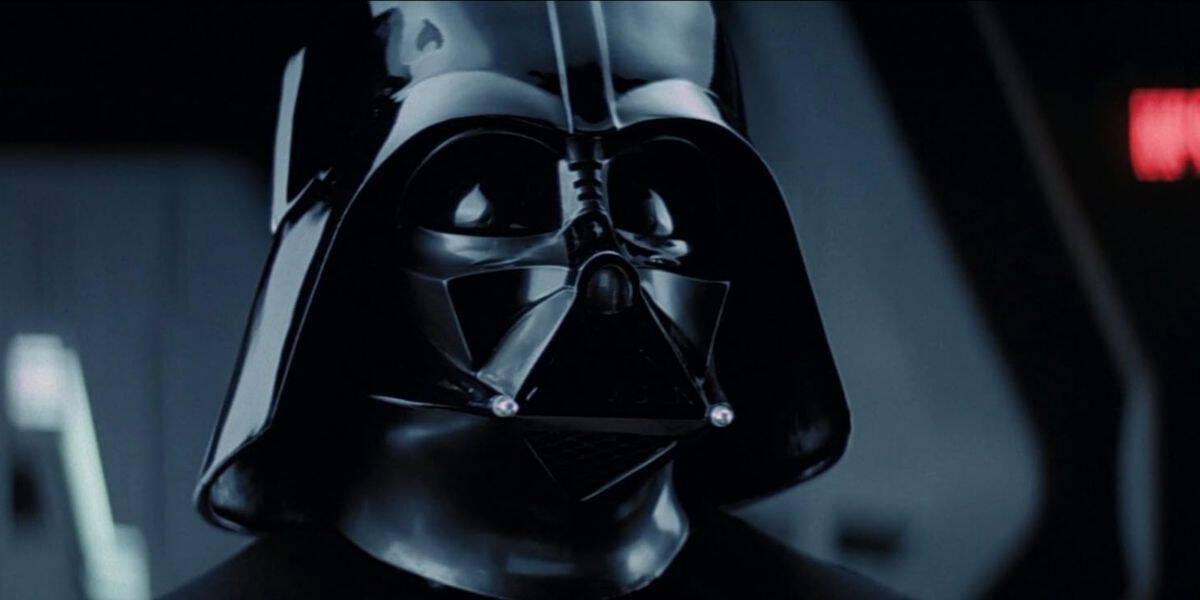 Darth Vader, in his iconic black helmet and mask, looms in a shadowy corridor reminiscent of his legendary appearances, inviting Star Wars fans to experience the epic presence made famous by Hayden Christensen.