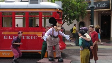 Mickey Mouse and a red trolley in a Newsies show at Disney California Adventure Park.