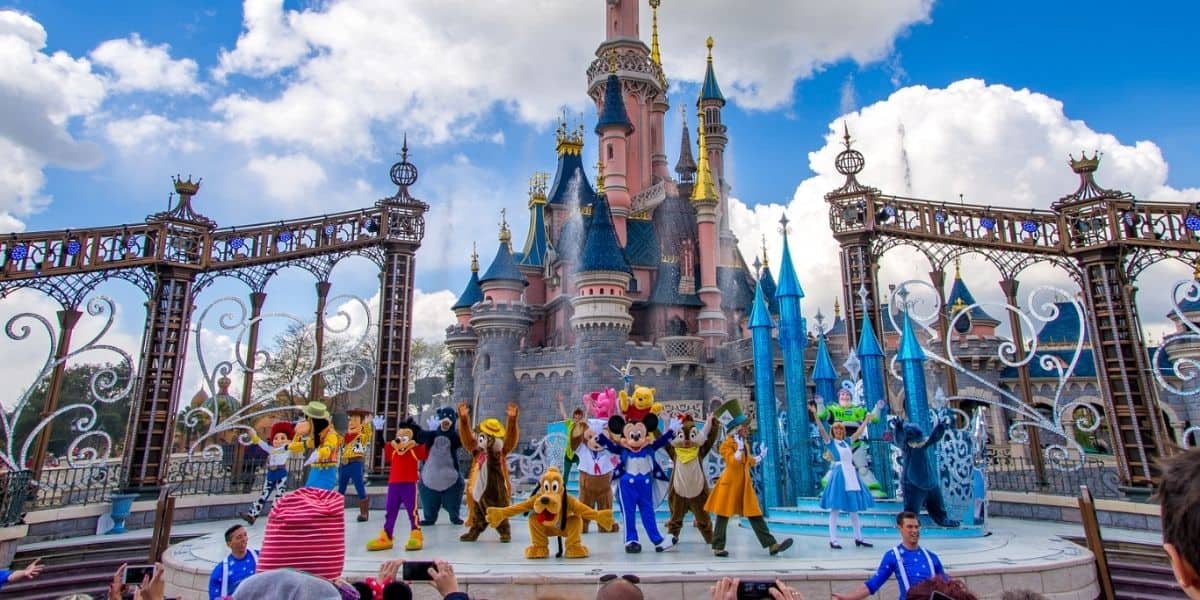 mickey and friends perform with castle in the background in disneyland paris