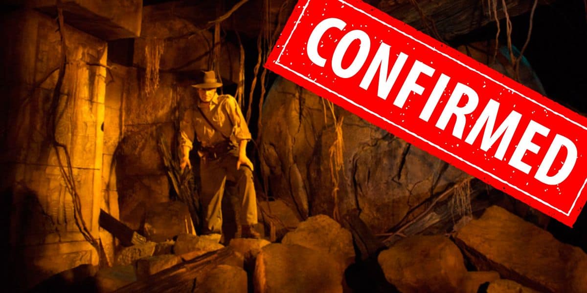 Indiana Jones stands among ancient ruins, his iconic fedora in place, with a bold red “CONFIRMED” stamp across the image—signaling exciting new effects soon debuting on Indiana Jones Adventure at Disneyland.