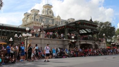 Guests gather by the Main Street train station at Magic Kingdom