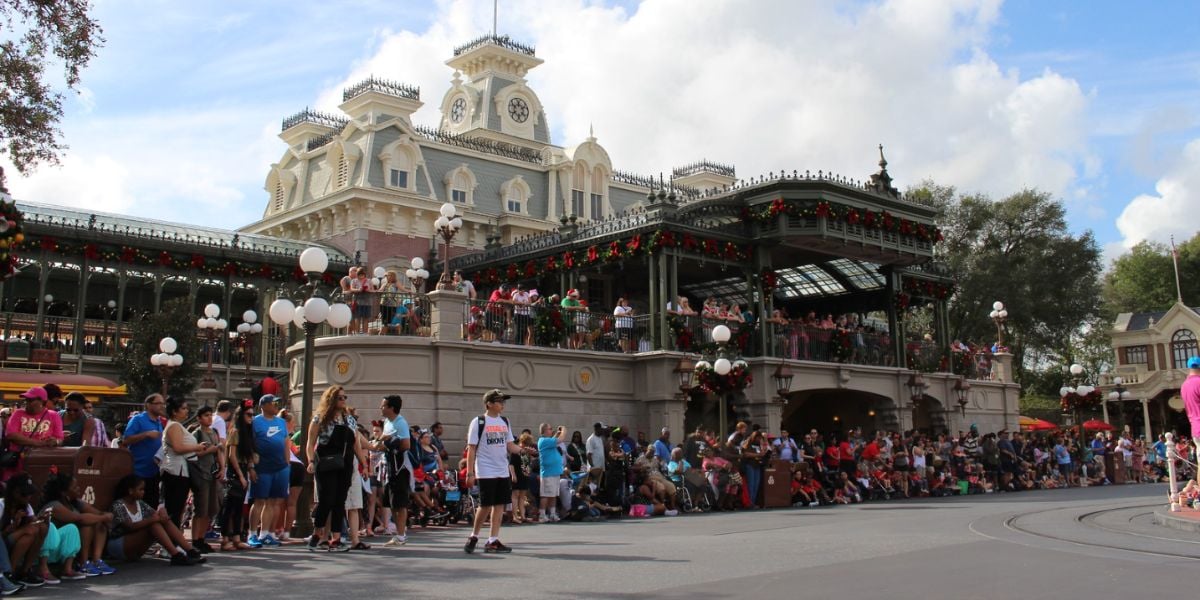 Guests gather by the Main Street train station at Magic Kingdom