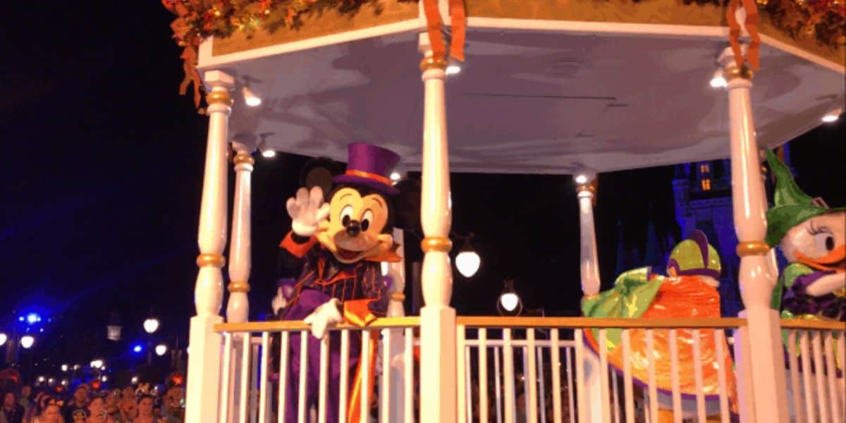 Mickey Mouse waves to fans from his Halloween parade float at Disney World.