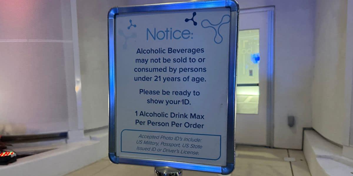 Sign at the theme park reads: Guests must be 21 or older to purchase or enjoy alcoholic beverages; limit one drink per Guest, valid ID required.