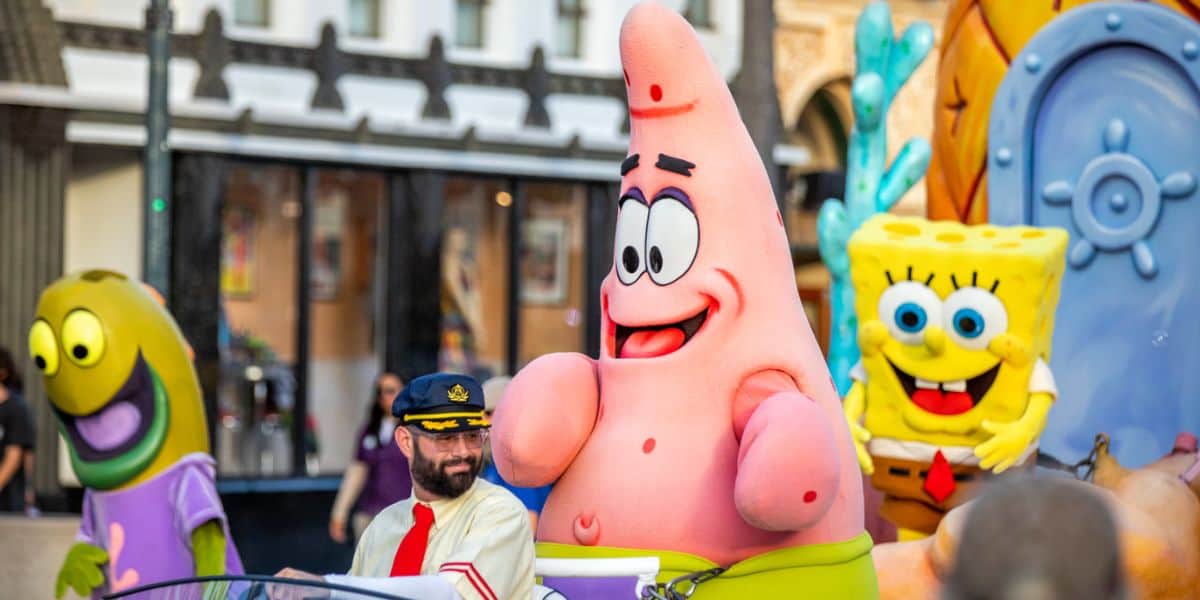 patrick and spongebob ride on parade float at universal theme park