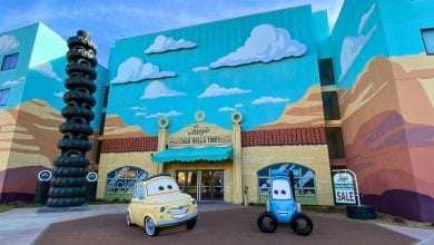 The entrance to Disney World’s Art of Animation Resort welcomes guests with eye-catching Cars movie murals, two life-sized car statues, and a towering stack of black tires on the left—an unforgettable landmark for fans arriving in 2027.