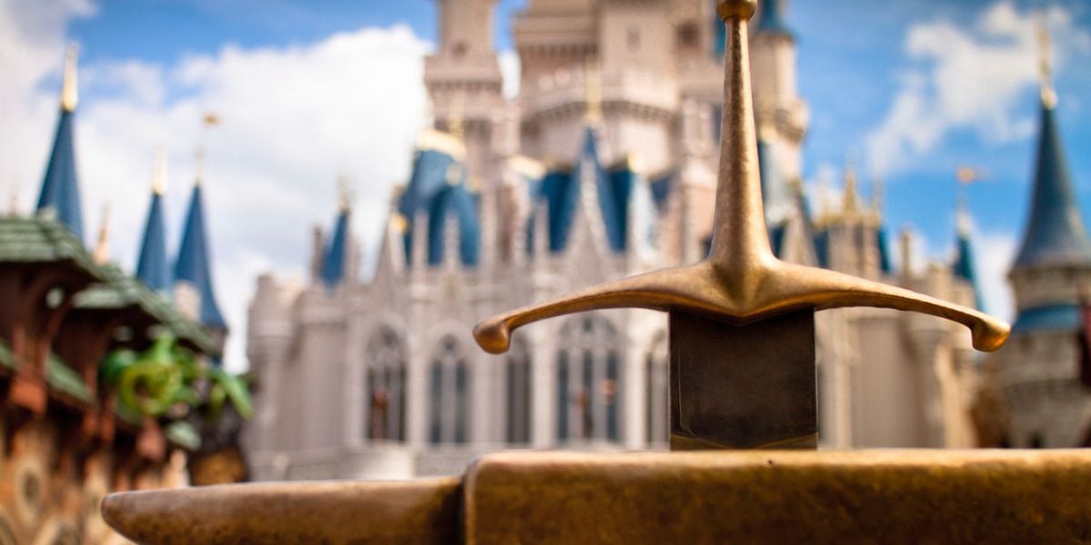 sword in the stone in front of magic kingdom's cinderella castle in disney world
