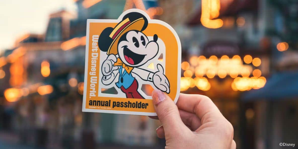 Walt Disney World annual passholder sticker featuring Mickey Mouse held up proudly, with a blurred street in the background—celebrating exclusive Passholder perks and magical benefits at Disney World.