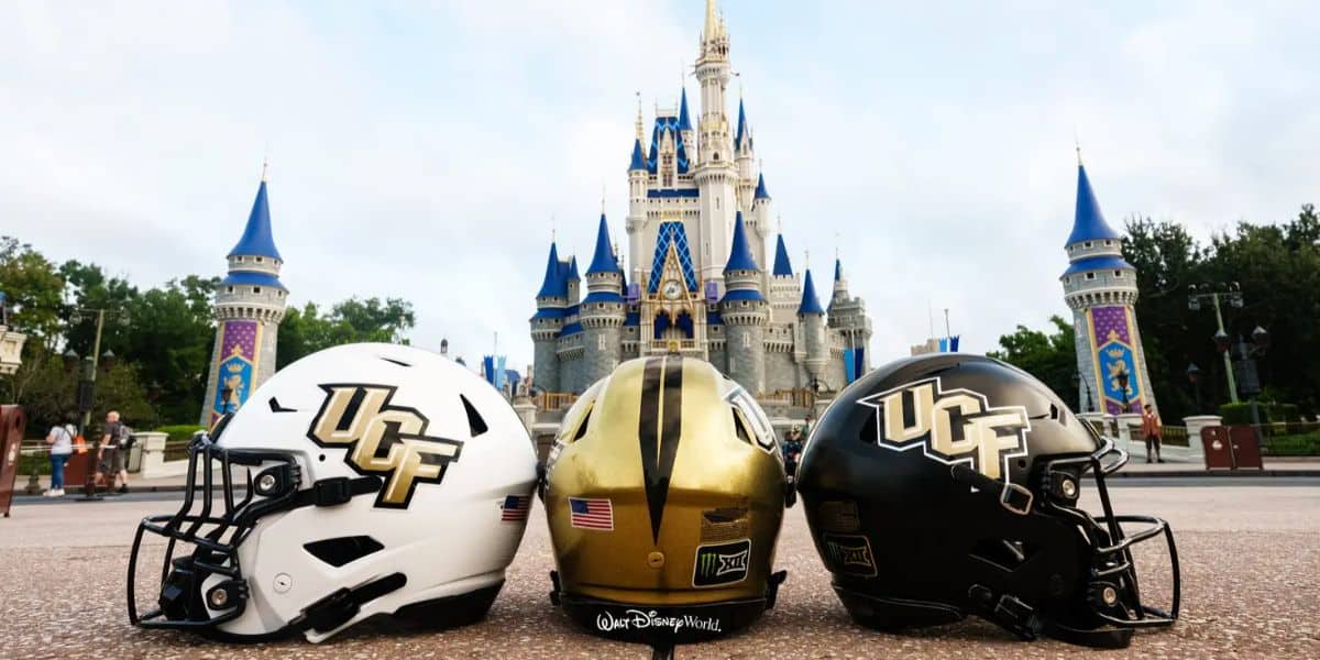 Three UCF football helmets displayed in front of Cinderella Castle at Disney World