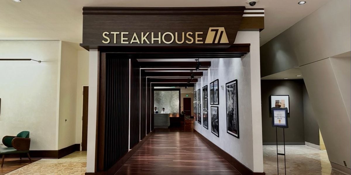 Stepping into Steakhouse 71 at Disney’s Contemporary Resort, you’ll spot sleek wood floors, classic framed Disney photos lining the walls, and a stylish host stand waiting at the end—all setting the stage for an unforgettable dining adventure for Walt Disney World fans.