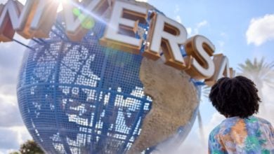 Universal Orlando's iconic spinning globe and a guest standing in front of it