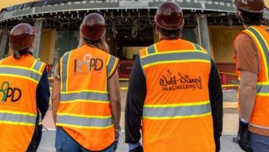four construction workers wearing "walt disney world imagineers" work outfits