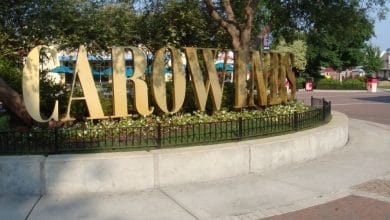 Large gold Carowinds logo at the park entrance.