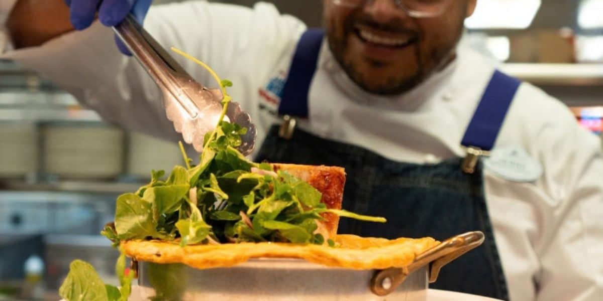 A chef garnishes a dish inside Be Our Guest at Magic Kingdom.
