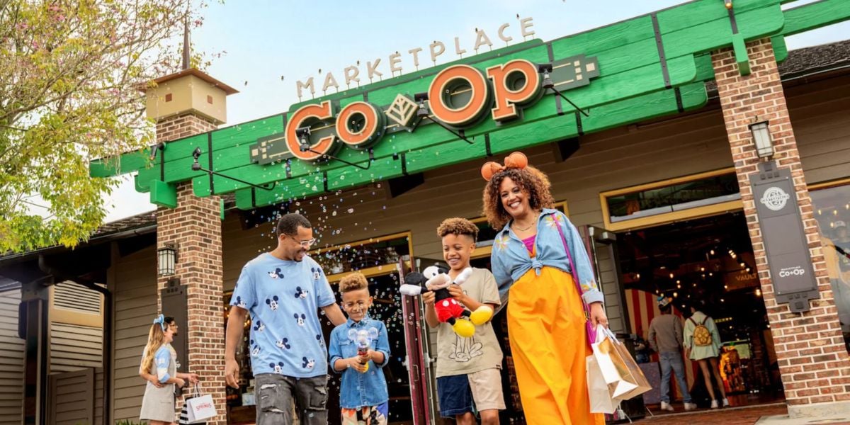 A family walks in front of the Marketplace Co-Op at Disney Springs.