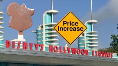 A Mickey ice cream bar held before a “Price Increase” sign at the entrance to Disney World.