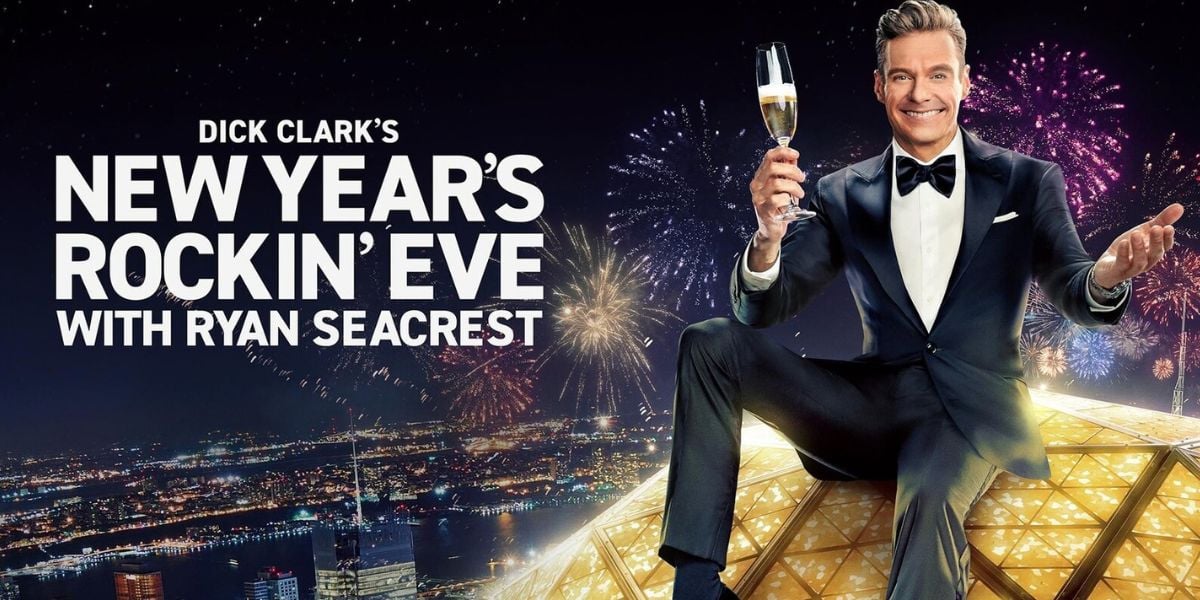 Ryan Seacrest toasts with champagne atop the Dick Clark’s New Year’s Rockin’ Eve ball as fireworks illuminate the celebration.