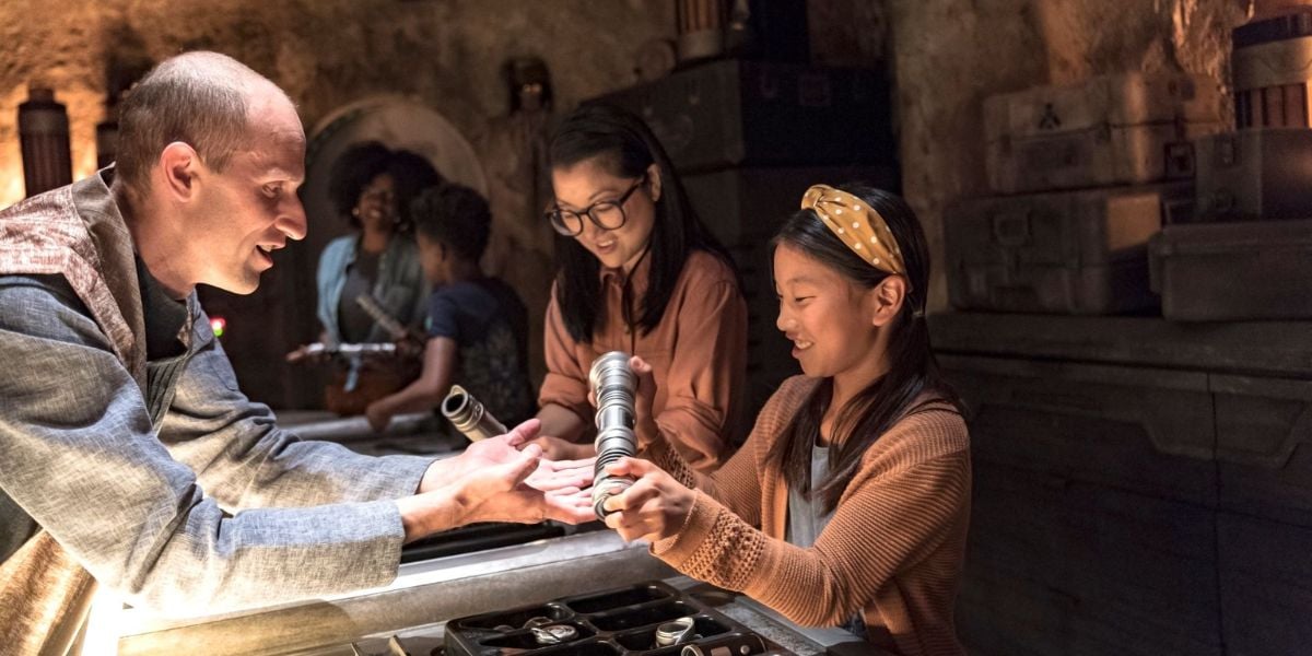 A guest builds a custom lightsaber at Savi’s Workshop in Star Wars: Galaxy’s Edge